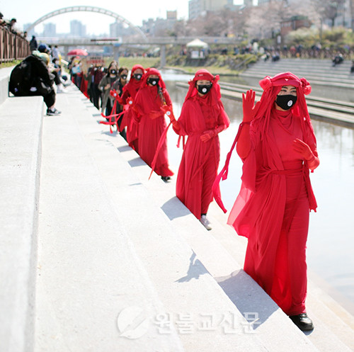 기후위기의 심각성을 알리기 위한 행사에서 ‘붉은 정령들’ 퍼포먼스 팀이 앞서걷고 다양한 단체와 시민들이 함께 걸었다.