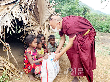 보드가야의 빈민거주지에서 식량꾸러미를 나눠주고 있는 아난다 스님.