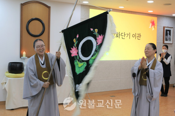 김성효 여자정화단 총단장이 최심경 신임 총단장에게 정화단기를 전달했다.